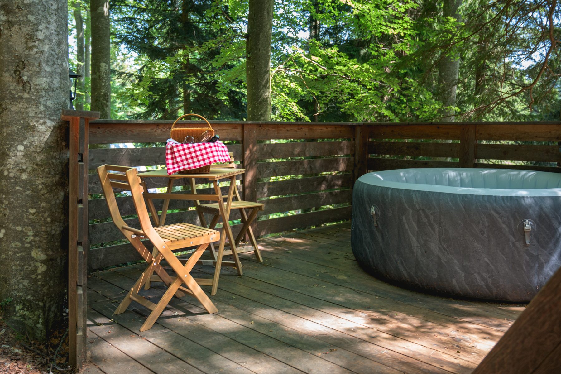 A wooden outdoor hot tub on a private terrace in summer